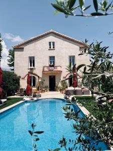 a large house with a swimming pool in front of it at Villa Maskali in Cuxac-dʼAude