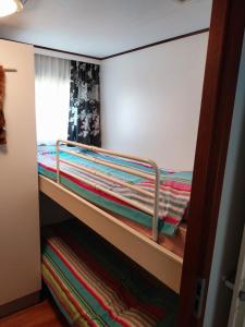 a bunk bed in a bedroom with colorful blankets at Chalet in Drenthe te huur aan de rand van het bos Drents Friese Wold, veel PRIVACY en RUST in Hoogersmilde