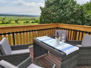einen Tisch und Stühle auf einer Terrasse mit einer Flasche Wein in der Unterkunft Ferienhaus Eisenberg in Vaskeresztes