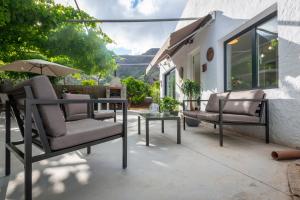eine Terrasse mit 2 Stühlen, einem Tisch und einem Sonnenschirm in der Unterkunft Villa Los Naranjos in Tenteniguada