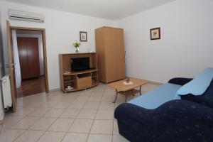 a living room with a couch and a tv at Apartmani Radan in Pag
