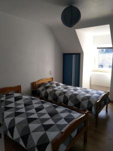 una camera con un letto a scacchi bianco e nero di Maison de village, golfe du Morbihan a Le Hézo