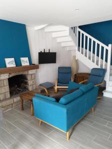 un soggiorno con divano blu e camino di Maison de village, golfe du Morbihan a Le Hézo