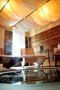瓦爾季採的住宿－Wine & Wellness hotel Besední dům，一间设有桌子、长凳、桌子和天花板的房间