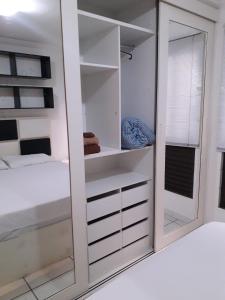 a bedroom with white cabinets and a mirror at Kit no Lago Norte CA 02 in Brasília