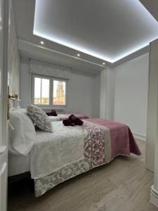 a white bedroom with a bed and a window at Apartamentos C&E in Haro