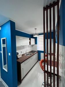 una cucina con pareti blu e una sedia in camera di Luxury Apartment a Topliţa