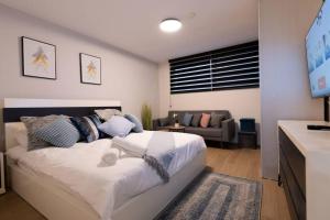 1 dormitorio con 1 cama y sala de estar en O&O Group - The SeaGate Estate suites - Suite 1 en Rishon LeẔiyyon