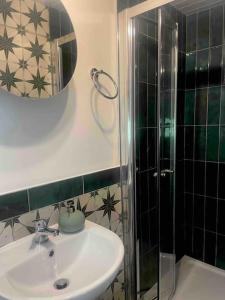 a bathroom with a sink and a shower at Railway cottage Annascaul in Annascaul