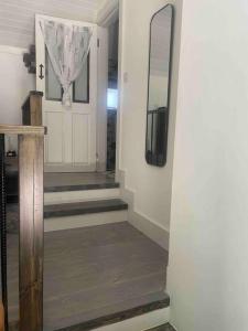 a hallway with stairs and a mirror and a tv at Railway cottage Annascaul in Annascaul