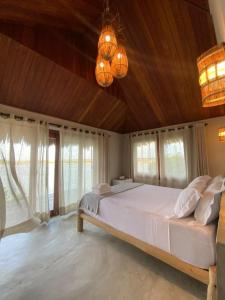 1 dormitorio con 1 cama blanca grande y ventanas en Tatadise, en Tatajuba