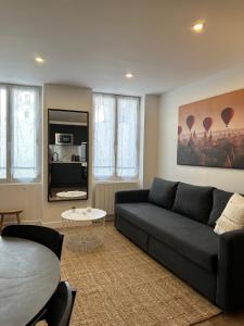 ein Wohnzimmer mit einem Sofa und einem Tisch in der Unterkunft Appart' Terrasse plein centre in La Ferté-Gaucher