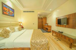 アラハバードにあるHotel Hira Inn-10mins From Railway Station & Bus Stationの大きなベッドと薄型テレビのある寝室