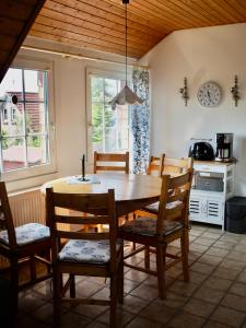 uma cozinha com uma mesa de madeira e cadeiras num quarto em Ferienwohnung direkt am Deich - Seerobbe - em Dornum