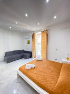 a bedroom with a large bed and a couch at Marechiaro Apartments in Palermo
