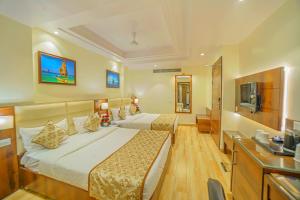 アラハバードにあるHotel Hira Inn-10mins From Railway Station & Bus Stationのベッド2台とテレビがあるホテルの部屋