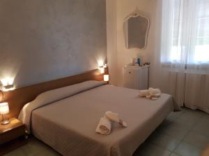 a bedroom with a bed with two towels on it at Hotel Villa Pagoda in Sirmione