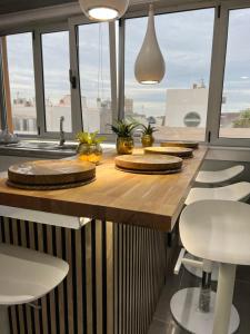 una cocina con una larga mesa de madera con sillas en Apartamento Victorio Las Canteras, en Las Palmas de Gran Canaria