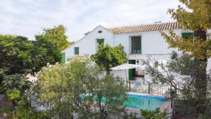 a white house with a swimming pool and trees at Cortijo Don Simón in Córdoba