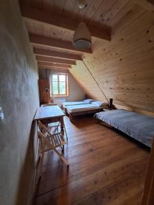 an attic room with two beds and a table at Lipie12a - pokoje in Lipie