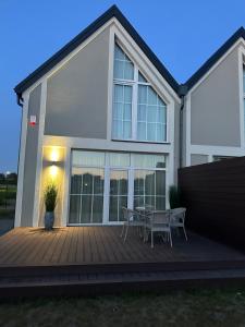 a house with a wooden deck with a table at D&A Apartamentai in Palanga