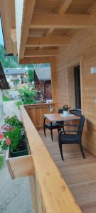 een houten terras met een tafel en een bank bij Innerraderhof in Prato alla Drava