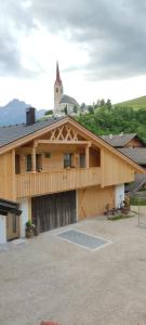 een groot houten gebouw met een klokkentoren bovenop bij Innerraderhof in Prato alla Drava