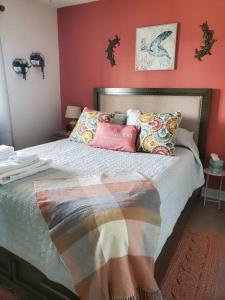 a bedroom with a large bed with red walls at The Lost Loggerhead- OBX Ocean view Beach House in Avon