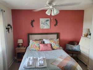a bedroom with a bed with a red wall at The Lost Loggerhead- OBX Ocean view Beach House in Avon