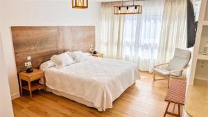 a bedroom with a large bed and a chair at Hostal Sorbas in Sorbas