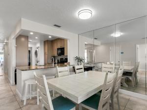 a dining room and kitchen with a table and chairs at Madeira Norte 304 in St Pete Beach