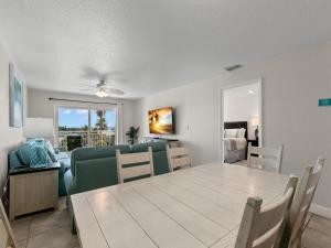 a dining room and living room with a table and chairs at Madeira Norte 304 in St Pete Beach +24 photos