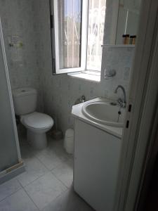 a bathroom with a sink and a toilet and a window at Panorama Rooms in Kyllini