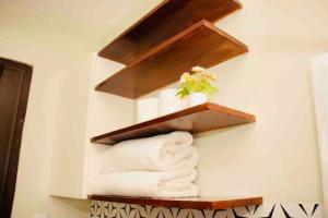 ein Regal mit Handtüchern und eine Pflanze an der Wand in der Unterkunft Fabulous Lakeshore House Fully Airconditioned Hi-speed WiFi 300 Mbps in Mexico