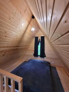 a bed in a wooden room with a window at Pine Chalet Kazbegi in Kazbegi