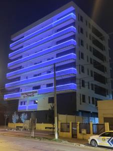 un edificio azul con un coche aparcado delante de él en Global Residence Lake View en Bucarest