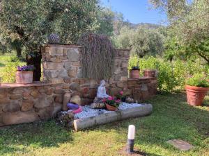 a garden with a stone wall and a statue at Agriturismo Buen Camino in Scarlino