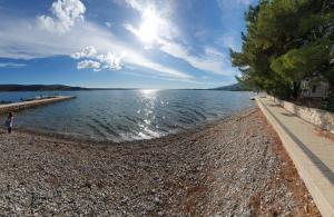 a large body of water with a person walking on the shore at Apartmani Malo more Seline in Seline