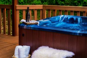 Mountainside - New Luxury Cabin-Fire Table-Hot Tub-3 Pools-PS5-Bears في غاتلينبرغ: حوض استحمام ساخن على السطح مع زجاجة من النبيذ