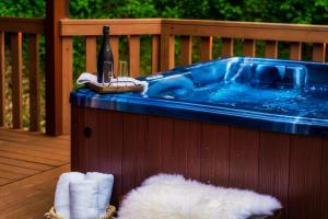 a hot tub on a deck with a bottle of wine at New Luxury Cabin~Fire Table~Hot Tub~3 Pools~PS5~Bears in Gatlinburg