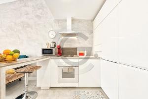 une cuisine avec des placards blancs et un comptoir dans l'établissement Tisalaya Bright Apartment, à Maspalomas