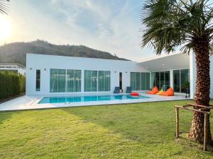 a villa with a swimming pool and a palm tree at Dani Villa- Spacious Private pool villa 4 Bed 4 bath in Khao Tao