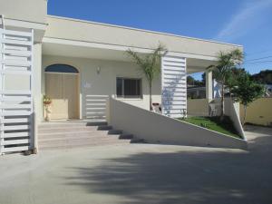 een wit huis met een trap en een veranda bij B&B Relax in Porto Cesareo