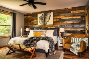 a bedroom with a wooden accent wall and a bed at New Luxury Cabin~Fire Table~Hot Tub~3 Pools~PS5~Bears in Gatlinburg