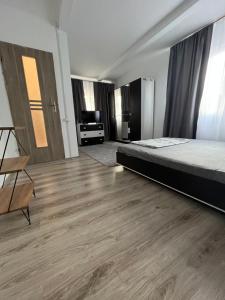 a bedroom with a bed and a wooden floor at Casa Dorina in Techirghiol