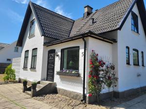une maison blanche avec des fleurs sur son côté dans l'établissement Bambina's Guest House, à Kristianstad