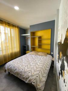 - une chambre avec un grand lit et une tête de lit jaune dans l'établissement Le Dolaizon, appartement avec ascenseur, au Puy-en-Velay