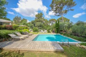 a swimming pool with a wooden deck next to a yard at Villa CONTEMPORAINE Piscine Montpellier in Montpellier