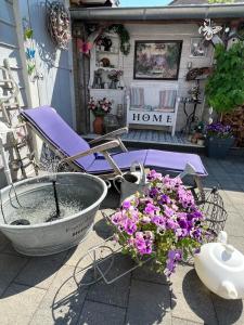 een patio met een stoel, bloemen en een bad bij Grote zolderverdieping met gezellig zitje in Woudenberg