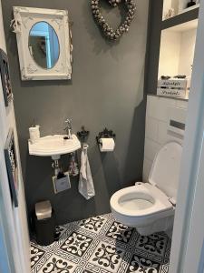 een badkamer met een wit toilet en een wastafel bij Grote zolderverdieping met gezellig zitje in Woudenberg